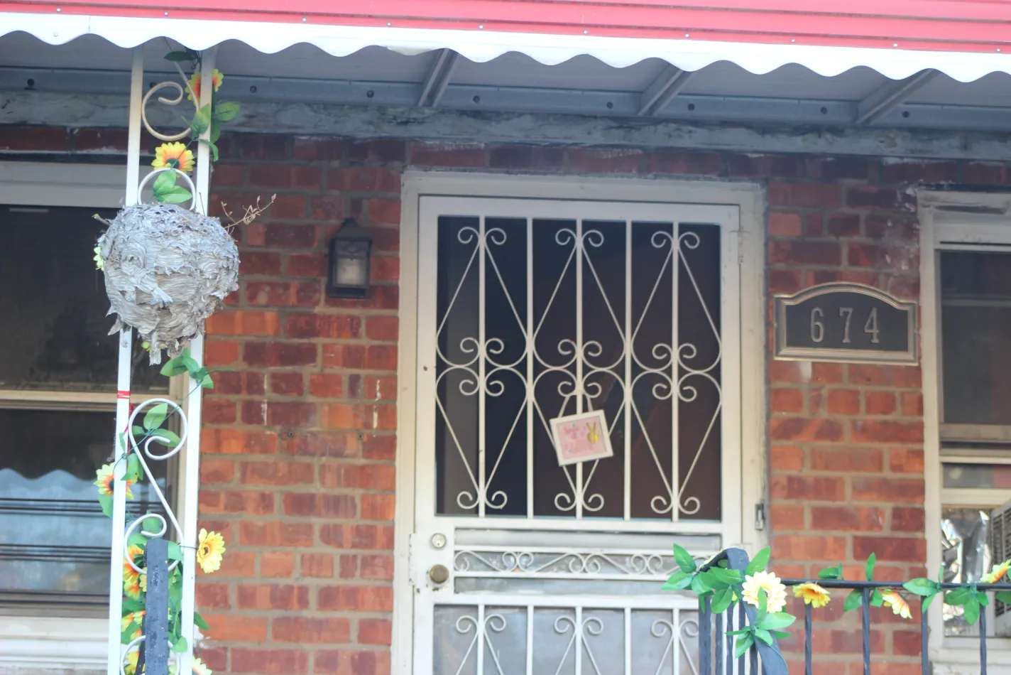 A decorative fake wasp nest on display in front of a home.